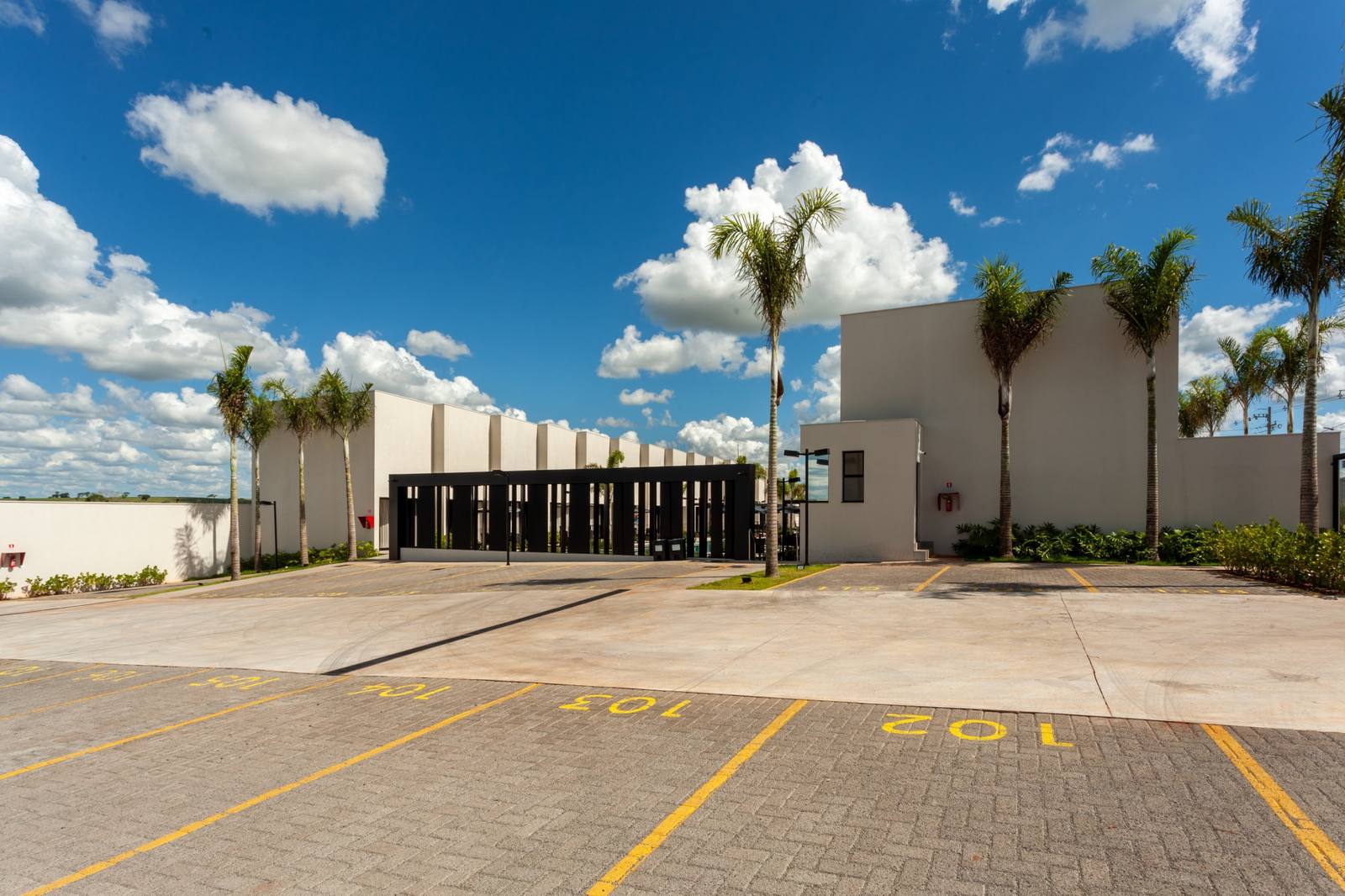 Entrada do condomínio com portaria e estacionamento
